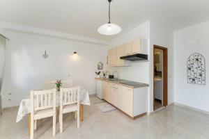 Una cocina y un comedor con mesa y sillas. en Apartment San, en Povljana