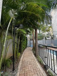 a walkway with palm trees and a street light at Apartamento em Brás, centro, eventos em São Paulo in Sao Paulo