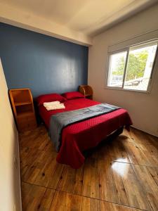 a bedroom with a bed with red sheets and a window at Apartamento em Brás, centro, eventos em São Paulo in Sao Paulo