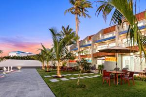 a resort with a table and chairs and palm trees at The sunset resorts - منتجع ساحل الغروب in Jeddah