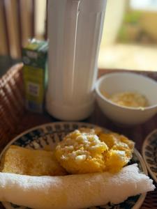 a plate of food on a table with a drink at Bangalô Encantador Praia da Baleia in Itapipoca