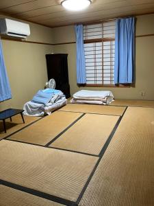 a room with two beds and blue curtains at Ichihara city house - Vacation STAY 20067 in Ichihara