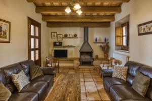 a living room with leather couches and a fireplace at La Torre de Dalt in Santa María de Camós
