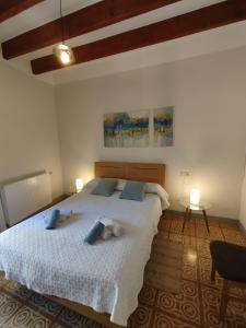 une chambre avec un grand lit avec deux animaux en peluche dessus dans l'établissement Ca l'Àvia Remei, à Castelló d'Empúries