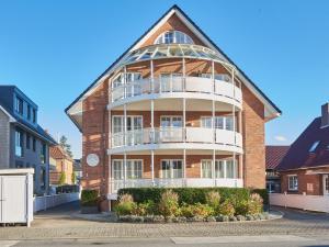 a large brick building with a white balcony at Techts Strandhaus in Timmendorfer Strand