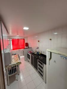 a small kitchen with a sink and a stove at Residencial Lagomar, sol e mar para relaxar! in Saquarema