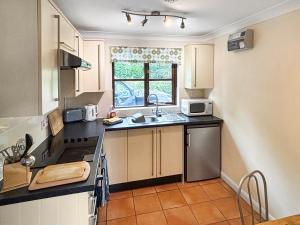 a small kitchen with a sink and a microwave at Fuschia Chalet in Framlingham