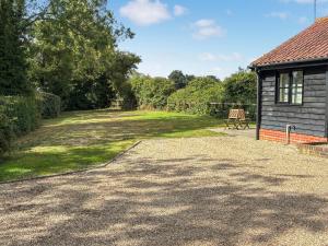 a large yard next to a house with a shed at Fuschia Chalet in Framlingham
