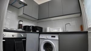 a kitchen with a washing machine and a sink at Charming Studio in the heart of birmingham in Birmingham