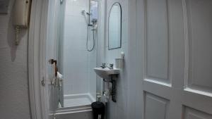 a bathroom with a sink and a shower and a mirror at Charming Studio in the heart of birmingham in Birmingham +6 photos