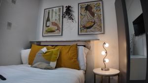 a bedroom with a bed and some pictures on the wall at Charming Studio in the heart of birmingham in Birmingham