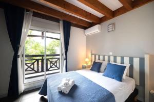 a bedroom with a bed with blue sheets and a window at COTTAGE BAMBOU classé 3 étoiles - 4 à 6 personnes - 2 chambres - avec piscine privée et accès direct à la plage et à l'esplanade de Boucan Canot avec ses bars et restaurants in Saint-Gilles les Bains +8 photos