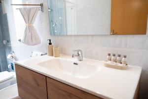 een badkamer met een witte wastafel en een spiegel bij Napolitano Rooms - Salerno Town in Salerno +67 foto's