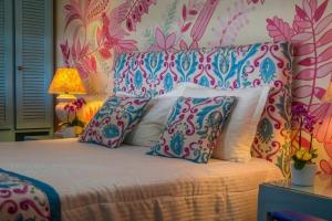 a bedroom with a bed with pillows and a floral wall at Mar Búzios inn in Búzios +19 photos