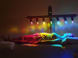 a person laying on a bed in a room with lights at Hotel Chytrov in Volfířov