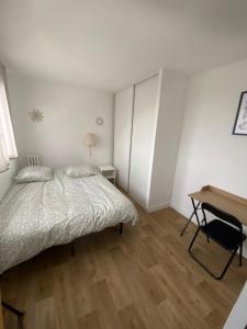 ein weißes Schlafzimmer mit einem Bett und einem Schreibtisch in der Unterkunft Appartement agréable Orleans centre-ville in Orléans