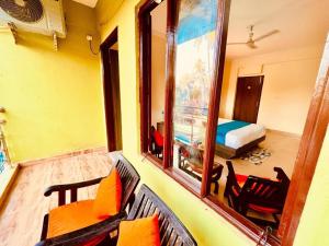 een kamer met een balkon, een bed en een spiegel bij Hotel Shivam Four Season in Calangute