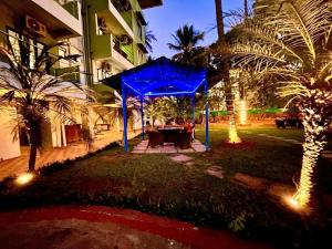 een blauw prieel voor een gebouw met palmbomen bij Hotel Shivam Four Season in Calangute