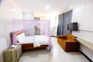 a bedroom with a canopy bed and a couch at Jade Inn in Arusha +9 photos