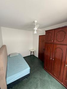 a bedroom with a bed and a wooden cabinet at Residencial Lagomar, sol e mar para relaxar! in Saquarema
