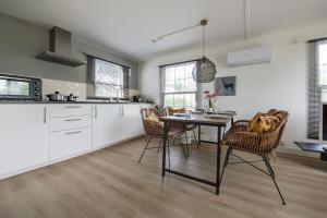 a kitchen and dining room with a table and chairs at 31, Ruimtelijk - Airco - Privé Parkeren - Natuur - Recreational Only in Oisterwijk