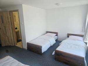 a room with three beds and a mirror at MAR-VIT Apartamenty in Przemyśl