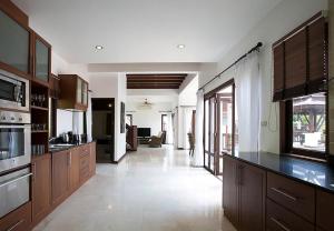 Una gran cocina con gabinetes de madera y una sala de estar. en Villa i Mae Phim med privat pool och havsutsikt, en Mae Pim