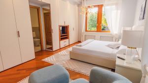 a white bedroom with a bed and two chairs at Villa Angela - Italian Homing in Desenzano del Garda +33 photos