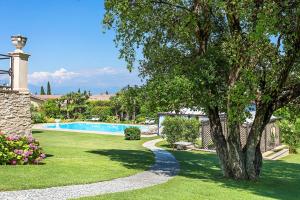 a yard with a swimming pool and a tree at Villa Angela - Italian Homing in Desenzano del Garda