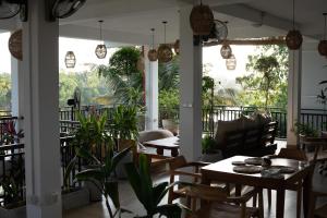 a restaurant with tables and chairs and a balcony at Sapiens home - Weligama bay in Weligama
