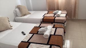 a group of three beds in a room with towels at L Escale de l Atlantique Dar Salma fibre optique piscines,clim&parking in Tangier