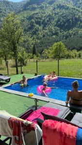 a group of people are in a swimming pool at Vila MM Boračko jezero in Konjic