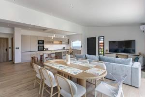 a kitchen and living room with a table and a couch at VILLA BELLEVUE classée 5 Etoiles - 4 chambres - piscine chauffée proche de l'aéroport et du centre de St Denis in Sainte-Marie