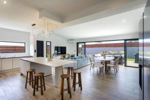 a kitchen and living room with a table and chairs at VILLA BELLEVUE classée 5 Etoiles - 4 chambres - piscine chauffée proche de l'aéroport et du centre de St Denis in Sainte-Marie +12 photos