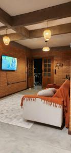 una camera da letto con un letto grande e una TV a schermo piatto di Chalé Sol - Vila Doiideira - centro de Ibitipoca a Lima Duarte