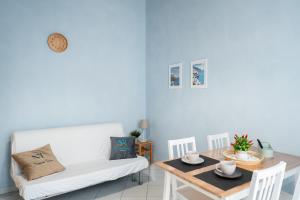 een woonkamer met een witte bank en een tafel bij Napolitano Rooms - Salerno Town in Salerno