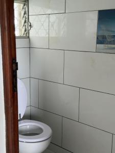 baño con aseo en una pared de azulejos blancos en Haut de villa Espérenza, en Les Abymes 15 fotos más