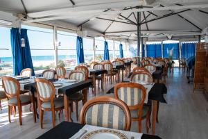 a row of tables and chairs in a restaurant at DA MARIA'S rooms in Lido di Ostia