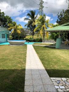una pasarela frente a un patio con palmeras en Haut de villa Espérenza, en Les Abymes