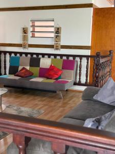 un sofá con almohadas coloridas en la sala de estar. en Haut de villa Espérenza, en Les Abymes
