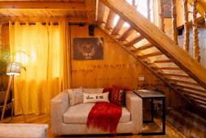 a living room with a couch and a staircase at THE WOODEN HOUSE in Msaranga +17 photos