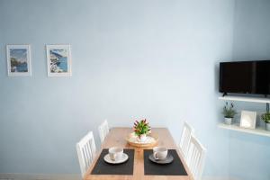 een eetkamer met een tafel met stoelen en een tv bij Napolitano Rooms - Salerno Town in Salerno