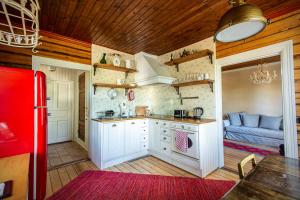 a kitchen with white cabinets and a red refrigerator at Villa Wolax in Kaarina