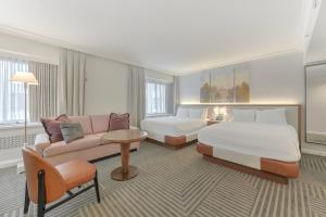 a hotel room with a bed and a couch at Capital Hilton in Washington +118 photos