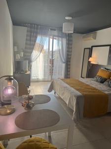 a bedroom with a bed and a table with rugs at Cozy Studio in Cannes in Le Cannet