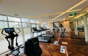 ein Fitnessstudio mit Laufbändern und Geräten in einem Raum in der Unterkunft Premium Studio Majestine by DAMAC, Business Hub in Dubai