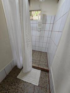 a bathroom with a shower with a shower curtain at Jacobin Hostel & Cabins in Drake