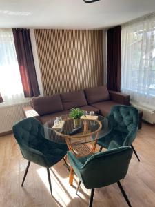 a living room with a glass table and green chairs at Pensiunea Carina in Bran +47 photos