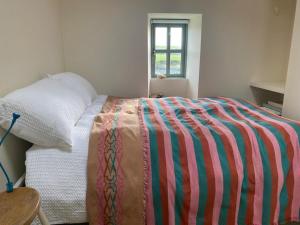 - une chambre avec un lit et une couverture colorée dans l'établissement Seaside Cottage Kinsale, à Feevaghmore