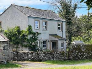 an old stone house with a stone wall at Greywalls in Penrith